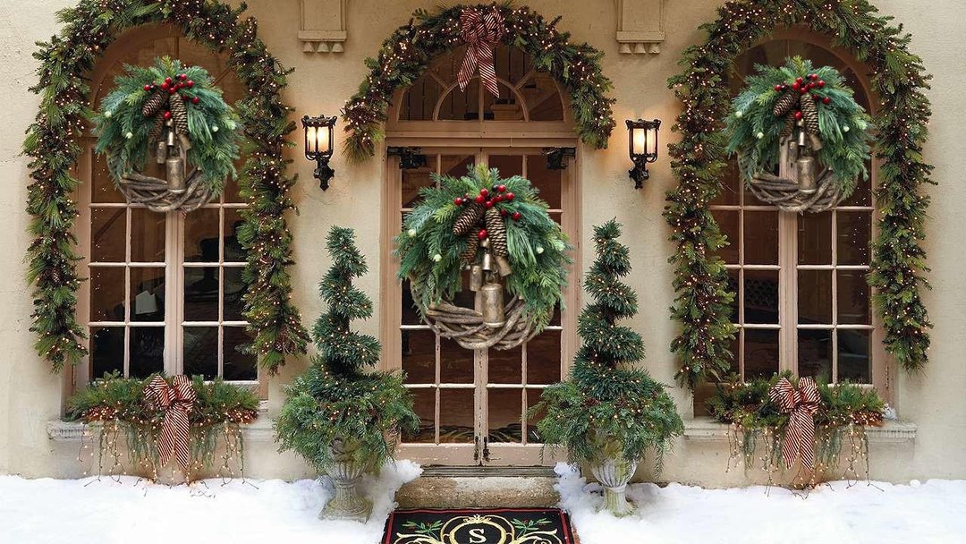 Corona de Navidad de estilo boho con base de ramas rústicas, piñas y campanas doradas