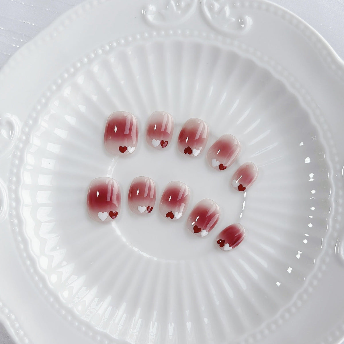 Uñas postizas degradadas con temática de corazones