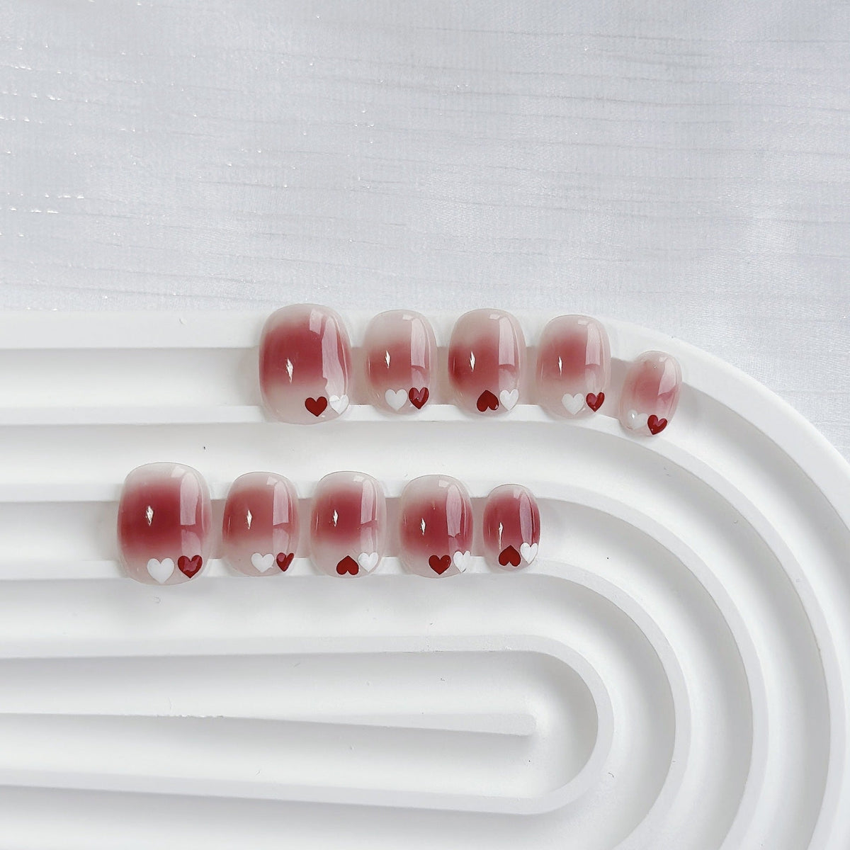 Uñas postizas degradadas con temática de corazones